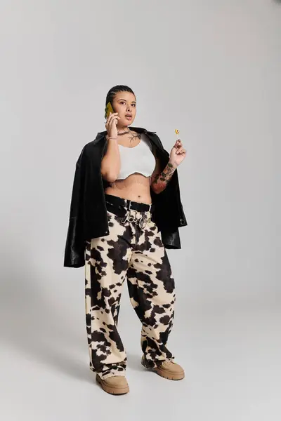 Une jeune femme élégante pose en toute confiance dans des vêtements et accessoires uniques. — Photo de stock