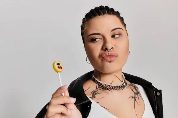Eine junge stilvolle Frau posiert mit einem Lutscher und zeigt ihr einzigartiges Modebewusstsein. — Stockfoto