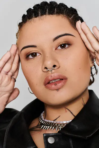 Young woman presents a striking fashion statement with edgy piercings and confident expression — Stock Photo