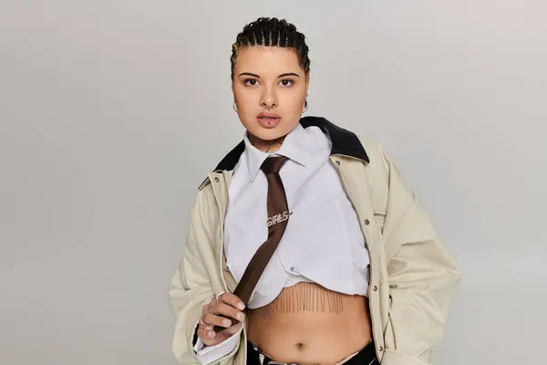 Una mujer joven muestra su aspecto de moda mientras que golpea una pose audaz en un espacio minimalista. — Stock Photo