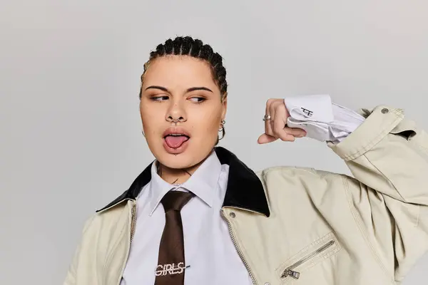 Mujer joven muestra una actitud juguetona mientras usa atuendo de moda en el interior. — Stock Photo
