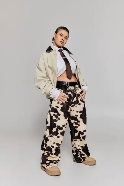A trendy young woman stands confidently, adorned in fashionable attire featuring striking patterns. — Stock Photo
