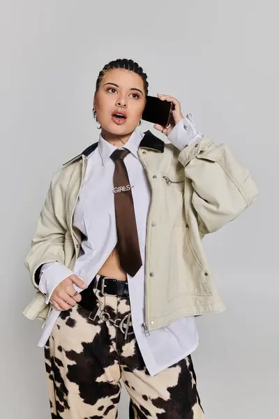 A stylish young woman confidently chats on the phone in a trendy studio. — Stock Photo