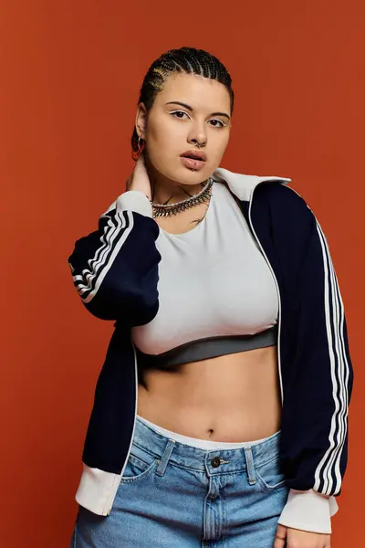 Une jeune femme respire la confiance avec sa tenue élégante, frappant une pose dans un cadre vibrant. — Photo de stock