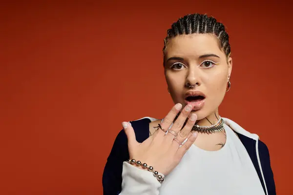 A young woman with braided hair showcases her fashion style while expressing surprise. — Stock Photo