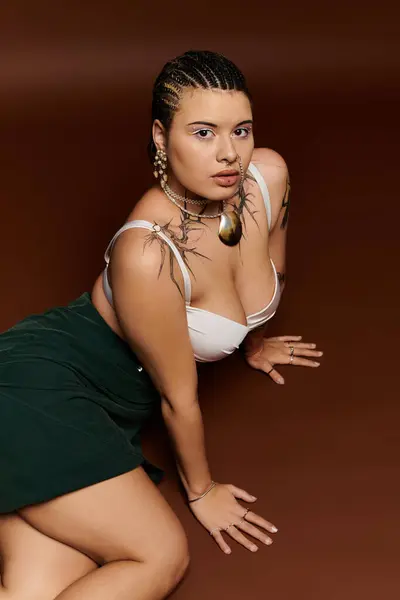 Una joven posa elegantemente con un atuendo elegante, destacando sus accesorios y tatuajes únicos. — Stock Photo