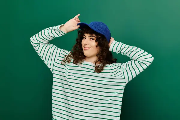 Emotional woman in a trendy outfit playfully poses with her cap, showcasing her youthful spirit. — Stock Photo