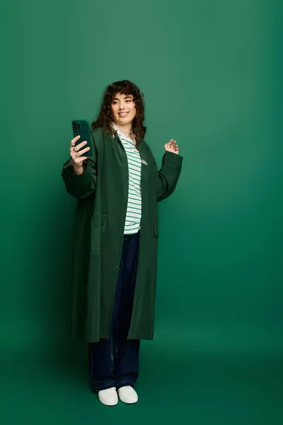 Emotional and fashionable young woman enjoys a moment while capturing a selfie in a trendy outfit. — Stock Photo