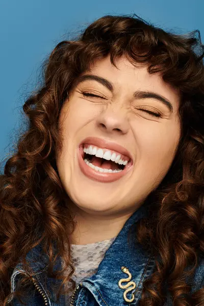 A joyful young woman laughs, flaunting her fashion in a vibrant backdrop. — Stock Photo