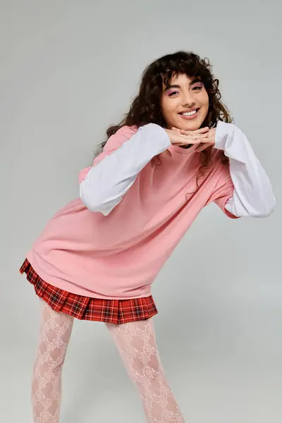 Fashion forward woman expresses joy and confidence through her playful pose in modern clothing. — Stock Photo