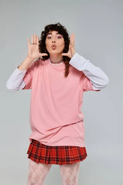 A fashionable woman in a playful stance showcases her stylish outfit and vibrant personality. — Stock Photo