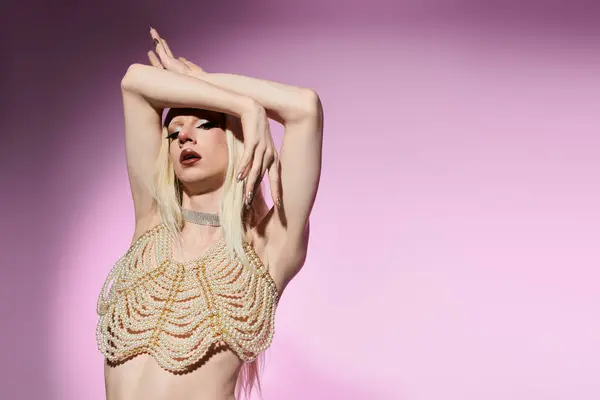 Uma drag queen chique golpeia uma pose artística contra um pano de fundo pastel, apresentando trajes elegantes. — Fotografia de Stock
