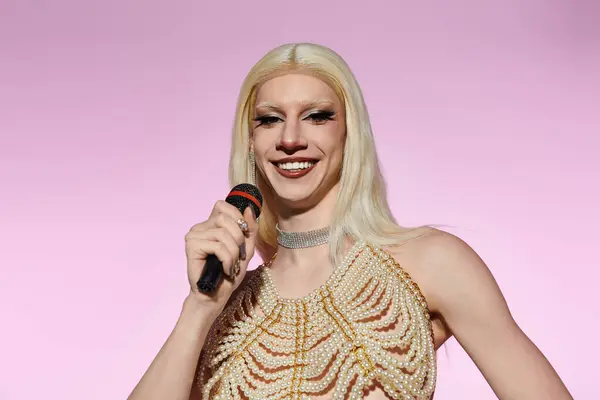 Eine selbstbewusste junge Drag Queen tritt auf der Bühne auf und versprüht mit Mikrofon Stil und Flair. — Stockfoto