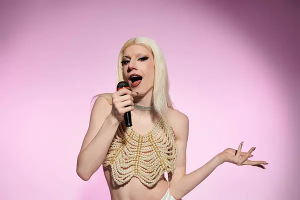 A drag queen dazzles the audience with a vibrant, confident performance under pink lights. — Stock Photo