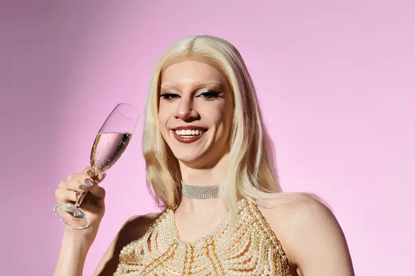 Una joven drag queen elegante lleva a cabo una bebida brillante, irradiando confianza en un entorno de moda. - foto de stock