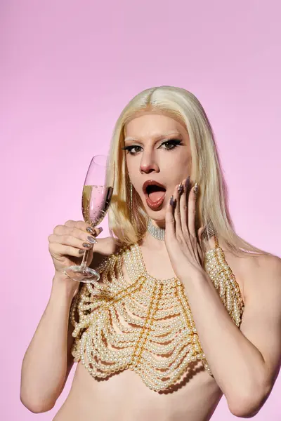 An eye catching drag performer joyfully enjoys a drink in chic pearl attire and a stunning pose. — Stock Photo