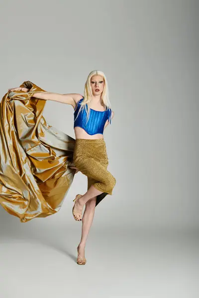 A confident young drag performer poses elegantly in a stylish, flowing outfit. — Stock Photo