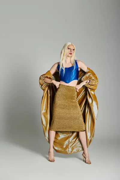 Eine selbstbewusste Drag Queen in atemberaubendem blauem Oberteil und goldenem Rock posiert mutig und lebendig. — Stock Photo