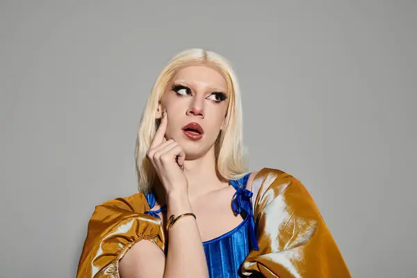 A confident young drag queen poses stylishly in a chic outfit and bold makeup. — Stock Photo