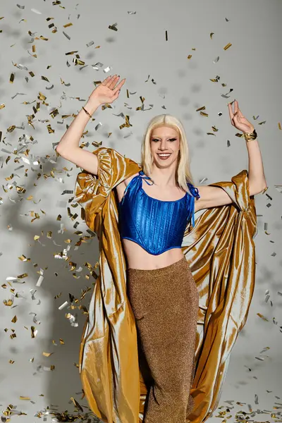 A vibrant drag queen exudes charisma while joyfully posing in colorful confetti. — Stock Photo