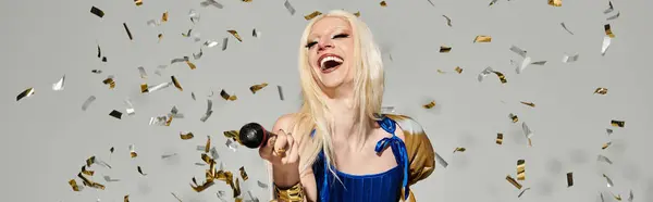 A stylish young drag queen celebrates life with joy, surrounded by shimmering confetti and laughter. — Stock Photo