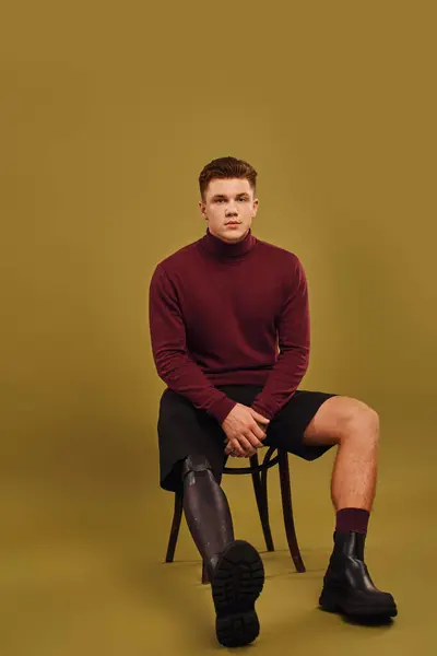 Hombre joven guapo posa con confianza en el atuendo de moda, destacando su pierna prótesis con estilo. - foto de stock
