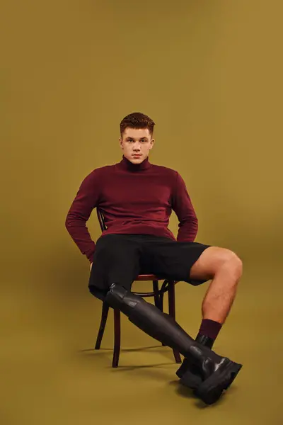 Um jovem com uma perna protética posa confiantemente em roupas da moda em um estúdio. — Fotografia de Stock