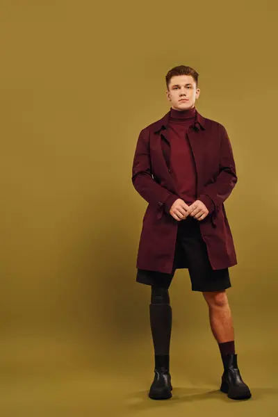 Um jovem elegante posa confiantemente em trajes da moda dentro de um ambiente de estúdio. — Fotografia de Stock