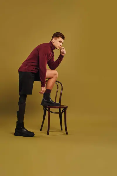 Um jovem com uma perna protética exibe um olhar elegante enquanto golpeia uma pose confiante. — Fotografia de Stock