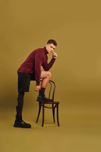 Ein modischer junger Mann posiert in trendiger Kleidung und zeigt seine Beinprothese. — Stockfoto