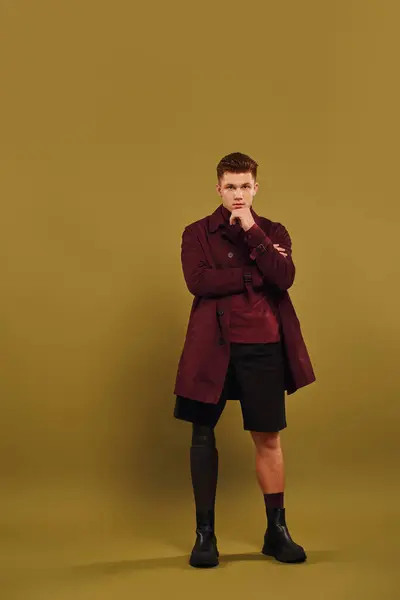 Jovem na moda mostra sua perna protética contra um pano de fundo colorido. — Fotografia de Stock
