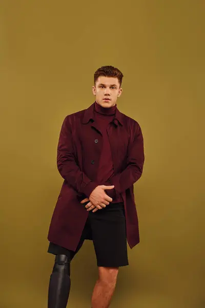 Jovem bonito posa confiantemente em trajes da moda, destacando sua perna protética em um estúdio. — Fotografia de Stock