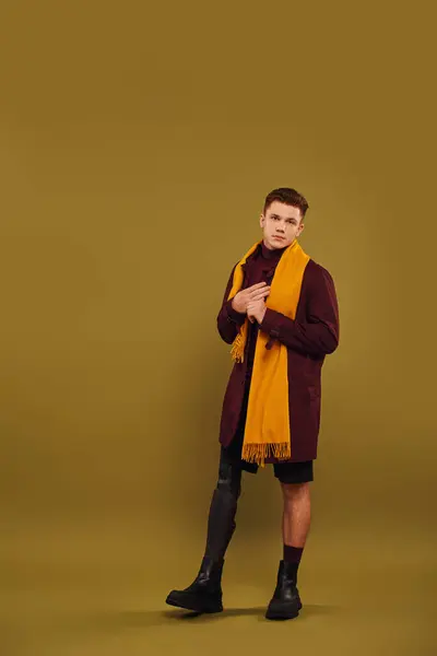 Un joven elegante con una pierna protésica posa con confianza en el estudio. - foto de stock