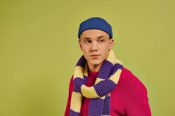 A stylish young man confidently models trendy clothes in a vibrant studio. — Stock Photo