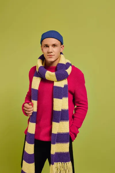 Young model displays a fashionable outfit with a cozy scarf against a bright backdrop. — Stock Photo