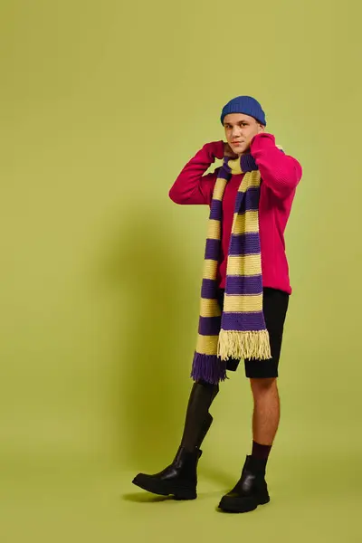 Jovem com uma perna protética posa confiantemente em trajes na moda contra um cenário vibrante. — Fotografia de Stock