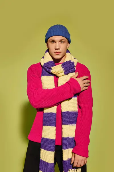 Handsome young model poses confidently in stylish attire with a playful scarf in the studio. — Stock Photo