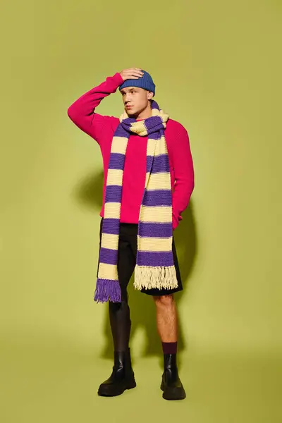 Bonito jovem indivíduo exibe com confiança trajes elegantes em um ambiente de estúdio vibrante. — Fotografia de Stock