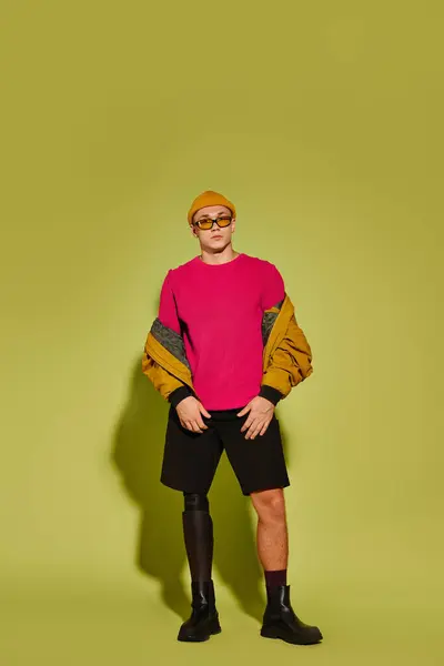 A stylish young man confidently poses in fashionable attire, highlighting his prosthetic leg. — Stock Photo