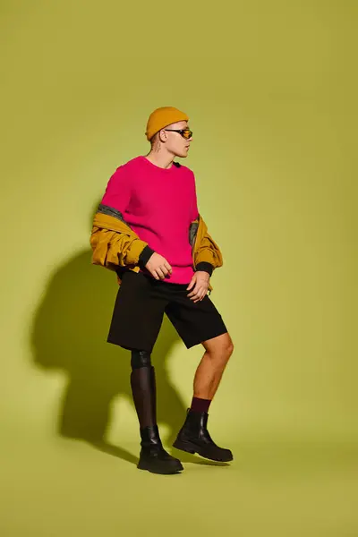 Um jovem elegante posa confiantemente em uma roupa vibrante, abraçando sua singularidade. — Fotografia de Stock