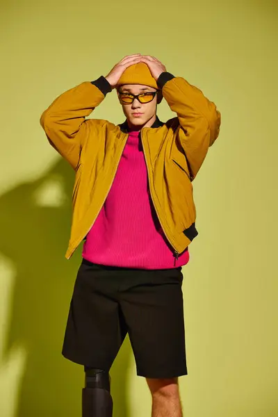 A stylish young man shows off his unique look and prosthetic leg in a studio. — Stock Photo