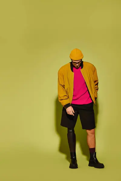Young man confidently shows off his stylish outfit and prosthetic leg. — Stock Photo