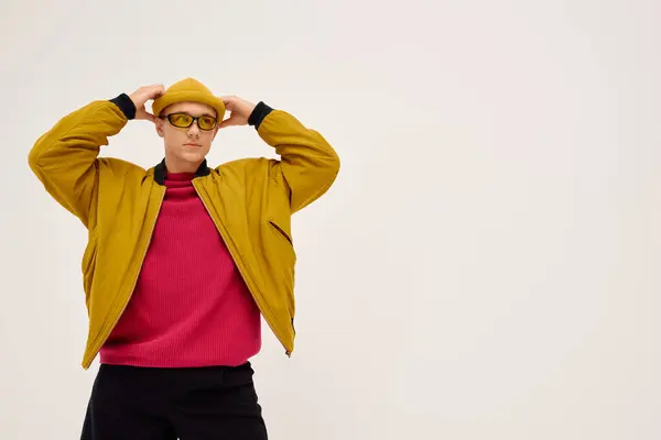 A handsome young man poses confidently in a trendy outfit, displaying his fashion sense in a studio. — Stock Photo