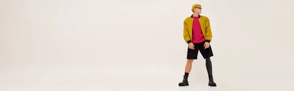 Bonito jovem confiantemente posa em trajes da moda com uma perna protética em um estúdio, banner — Fotografia de Stock