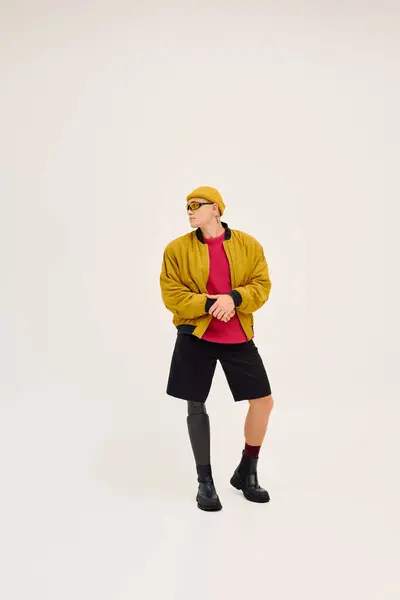 Um jovem com uma perna protética posa na moda em um estúdio, incorporando diversidade e estilo. — Fotografia de Stock