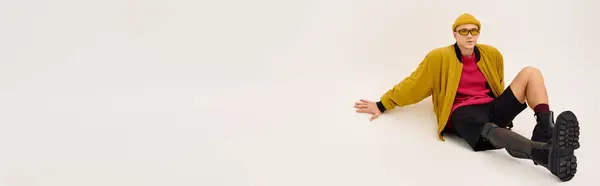 Jovem com uma perna protética posa elegantemente em traje na moda contra um pano de fundo simples, banner — Fotografia de Stock