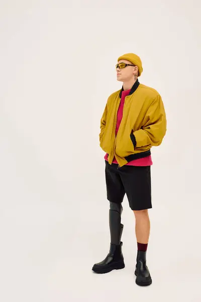 Um jovem bonito posa confiantemente em trajes na moda, destacando sua perna protética. — Fotografia de Stock