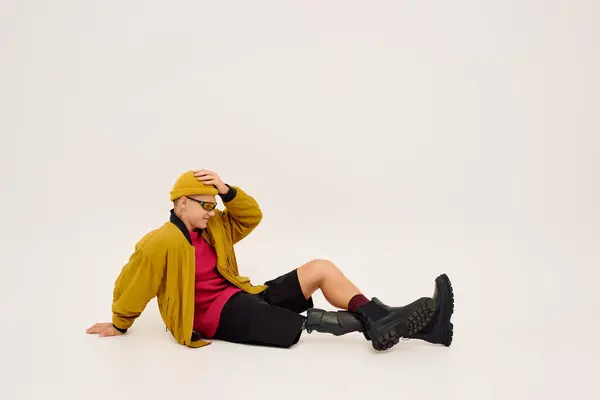Bonito jovem com uma perna protética posa confiantemente em trajes da moda, apresentando inclusão. — Fotografia de Stock