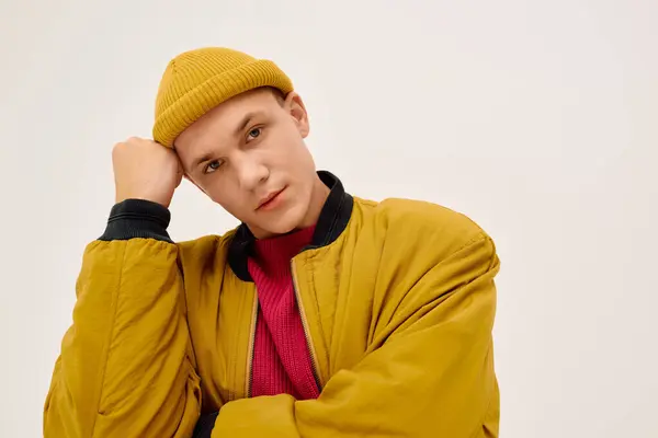 Un giovane uomo elegante posa con fiducia in abiti alla moda all'interno di uno studio moderno. — Foto stock