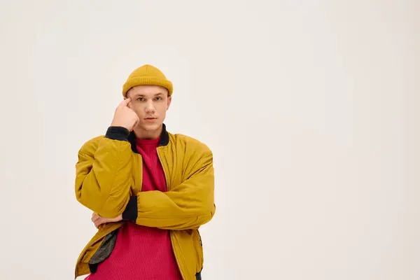 Fiducioso giovane modello mette in mostra lo stile vibrante in abiti alla moda all'interno di uno studio chic. — Foto stock